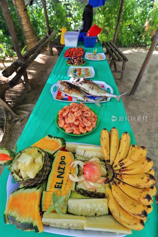 桌上有水果、虾、鱼和沙拉盘。Cudugnon Cave beach-El ndo - palawan - philippine -0879